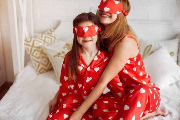 Cute mother and daughter at home in a pajamas — Stock Photo, Image