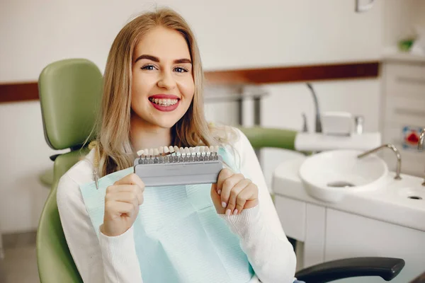 Hermosa chica sentada en el consultorio de dentistas — Foto de Stock
