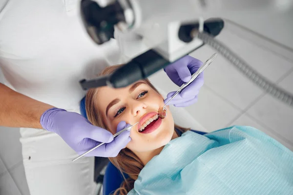 Hermosa chica sentada en el consultorio de dentistas —  Fotos de Stock