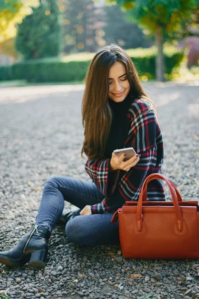 Fille à l'aide de son téléphone portable tout en marchant dans le parc — Photo