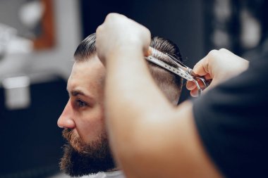 Berber dükkanında oturan şık bir adam.