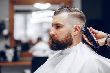 Berber dükkanında oturan şık bir adam.