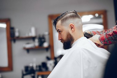 Berber dükkanında oturan şık bir adam.