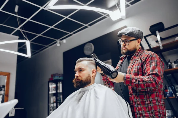 Stilvoller Mann sitzt in einem Friseurladen — Stockfoto