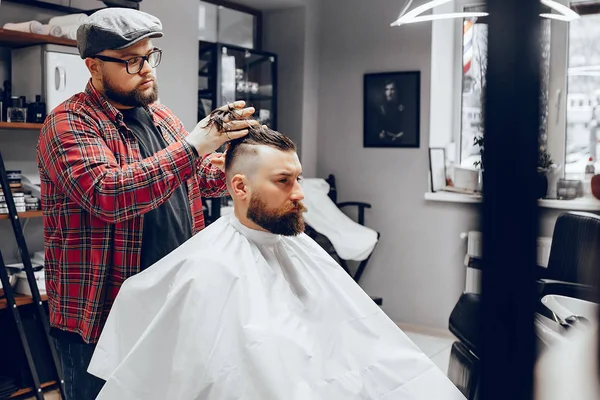 Elegante hombre sentado en una barbería — Foto de Stock