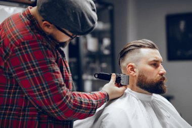 Berber dükkanında oturan şık bir adam.