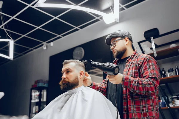 Stilvoller Mann sitzt in einem Friseurladen — Stockfoto