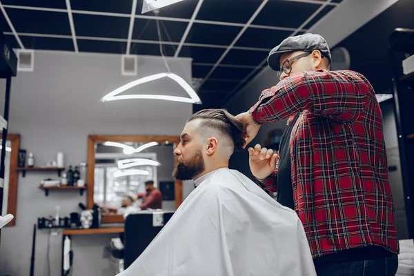 Stilvoller Mann sitzt in einem Friseurladen — Stockfoto