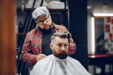 Berber dükkanında oturan şık bir adam.