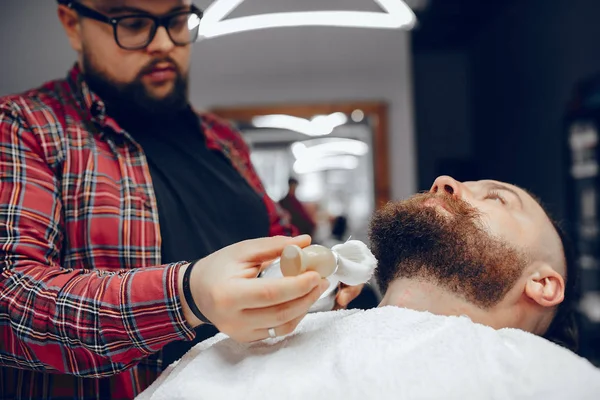 Stilvoller Mann sitzt in einem Friseurladen — Stockfoto