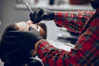 Berber dükkanında oturan şık bir adam.