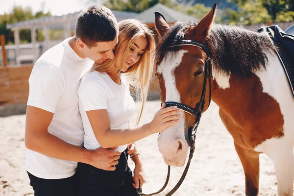 Belo casal passar o tempo com um cavalos — Fotografia de Stock