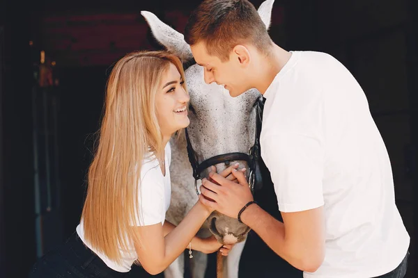 Belo casal passar o tempo com um cavalos — Fotografia de Stock