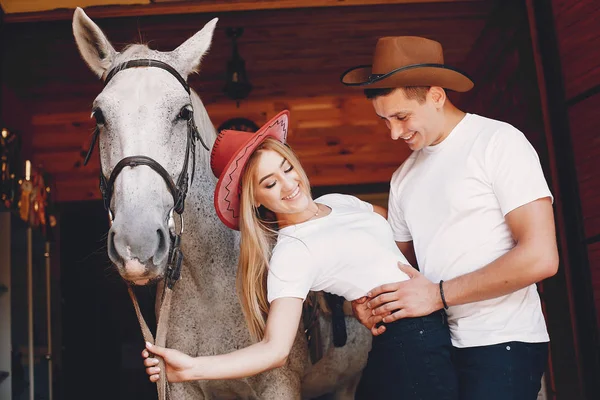 Belo casal passar o tempo com um cavalos — Fotografia de Stock