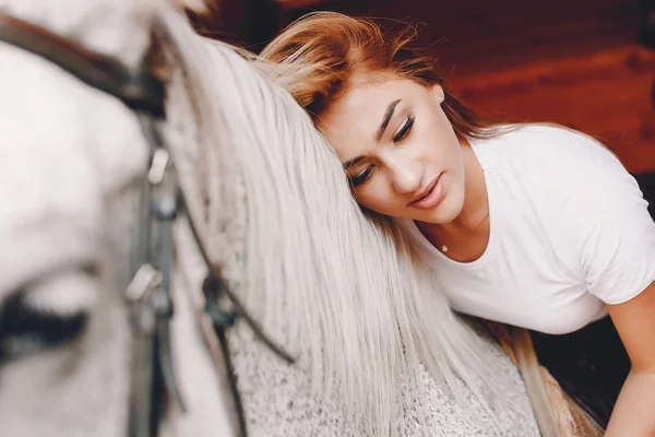 Elegant meisje in een boerderij met een paard — Stockfoto