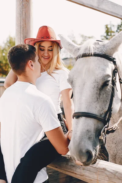 Belo casal passar o tempo com um cavalos — Fotografia de Stock