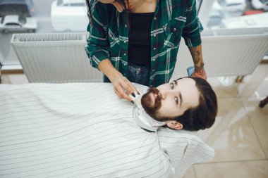 Berber dükkanında oturan şık bir adam.