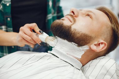 Berber dükkanında oturan şık bir adam.