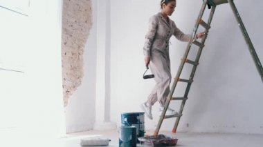 elinde boya rulo ile bir merdiven tırmanma kız