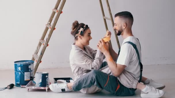 Glückliches Paar beim gemeinsamen Bemalen seiner ersten Wohnung — Stockvideo