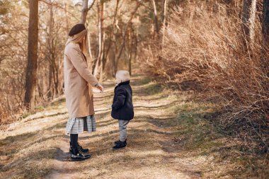 Anne ve oğlu yaz parkında oynuyorlar.