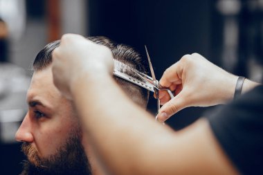 Berber dükkanında oturan şık bir adam.