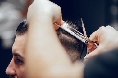 Berber dükkanında oturan şık bir adam.