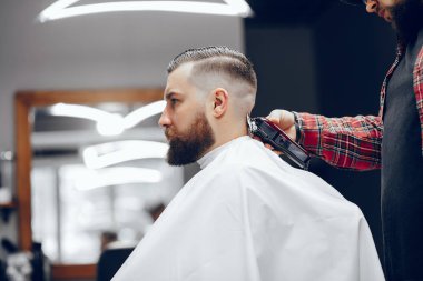 Berber dükkanında oturan şık bir adam.