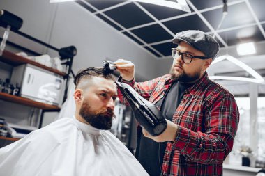 Berber dükkanında oturan şık bir adam.