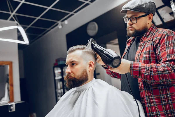 Stilvoller Mann sitzt in einem Friseurladen — Stockfoto