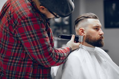 Berber dükkanında oturan şık bir adam.