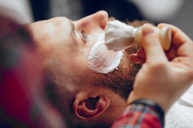 Berber dükkanında oturan şık bir adam.