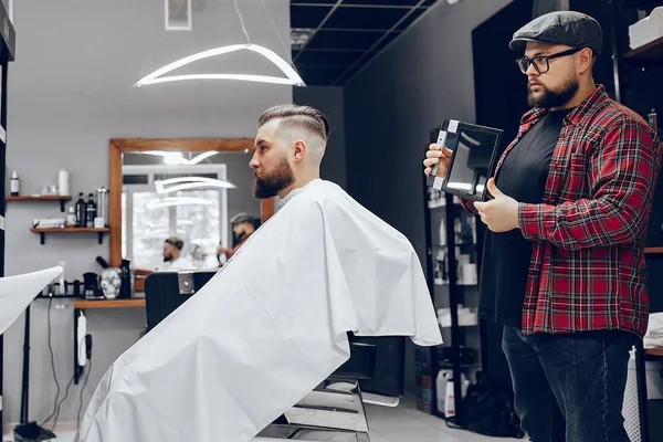 Elegante hombre sentado en una barbería —  Fotos de Stock