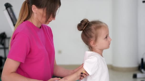 Mãe massageando menina no ginásio — Vídeo de Stock