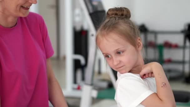 Moeder masseren klein meisje in de sportschool — Stockvideo