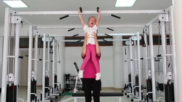 Spor salonunda küçük bir kız ile çalışan eğitmen — Stok video