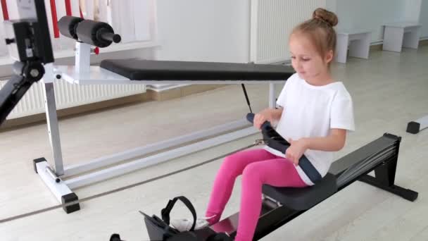 Entrenador haciendo ejercicio con una niña en el gimnasio — Vídeos de Stock