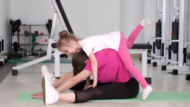 Entrenador haciendo ejercicio con una niña en el gimnasio — Vídeos de Stock