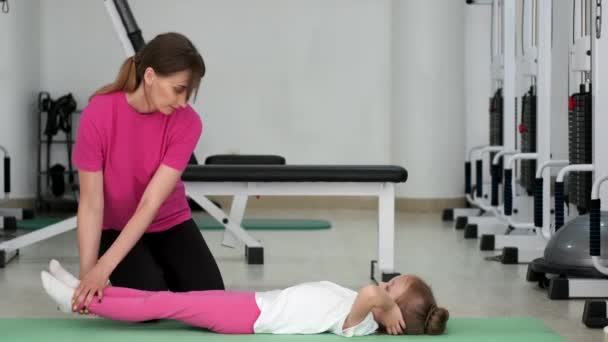 教练在健身房和一个小女孩一起锻炼 — 图库视频影像