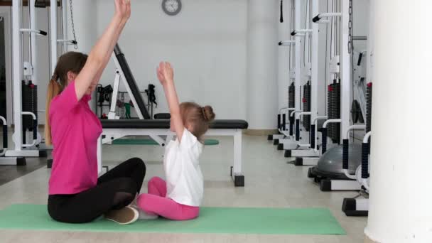 Entraîneur travaillant et faisant de l'exercice avec une petite fille au gymnase — Video