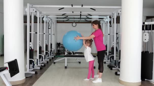 Trainer trainen met een klein meisje in de sportschool — Stockvideo