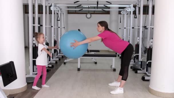 Tränare tränar med en liten flicka på gymmet — Stockvideo