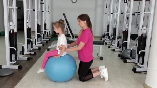 Trainer trainen met een klein meisje in de sportschool — Stockvideo