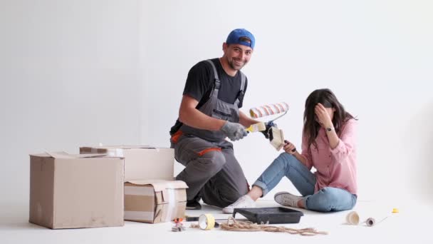 Пара розважається під час роботи і фарбування своєї квартири — стокове відео