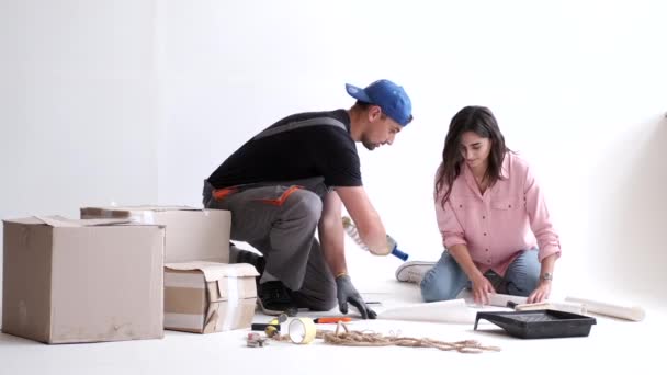 Jovem casal preparando para paredes de construção e pintura — Vídeo de Stock