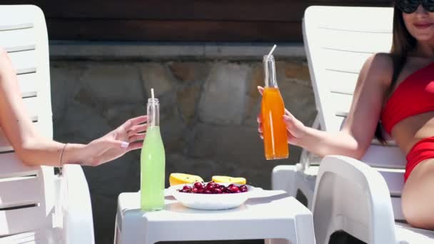 Dos chicas tumbadas junto a la piscina — Vídeos de Stock