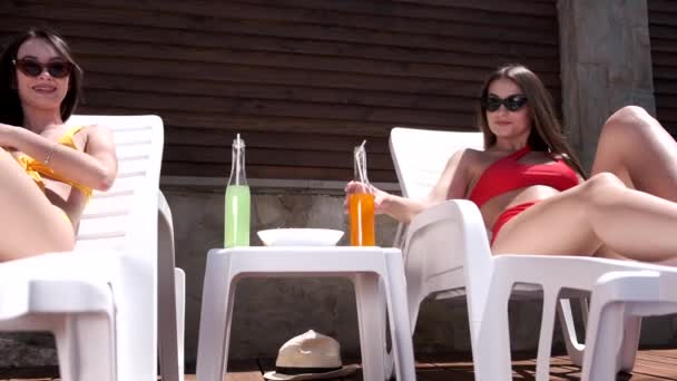 Two girls laying out by the pool — Stock Video