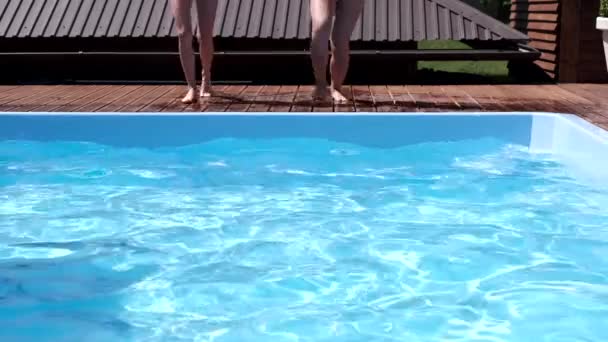 Dvě dívky skáčou do bazénu — Stock video