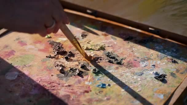 Θηλυκό καλλιτέχνη ζωγραφική έναν πολύχρωμο πίνακα σε εξωτερικούς χώρους — Αρχείο Βίντεο
