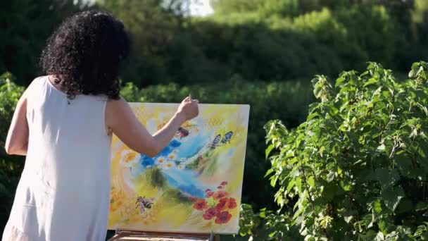 Female artist painting a colorful painting outdoors — Stock Video